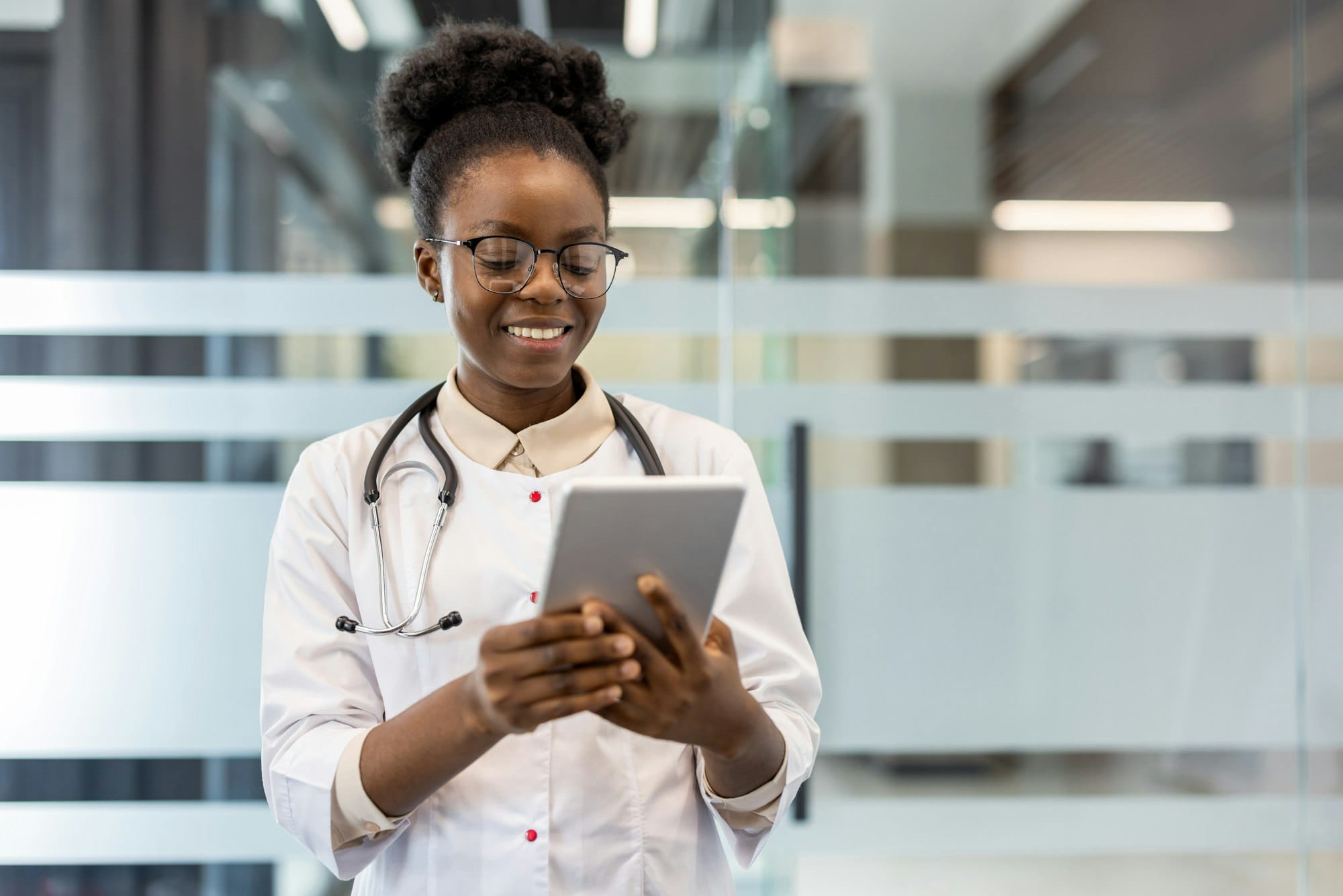Smiling doctor using a tablet in a modern medical office