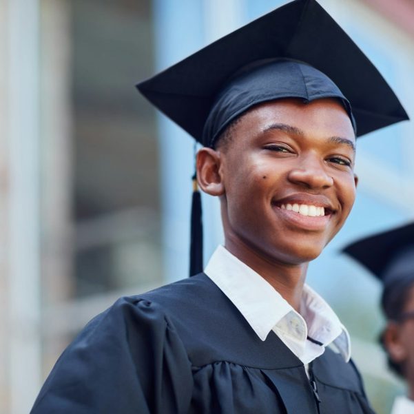 Portrait of a happy male student standing outside on his graduation day