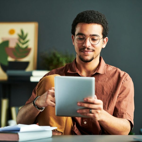 Young Middle Eastern male student looking at screen of tablet